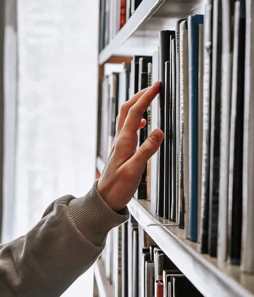 Autor explorando libros en librería - Editorial Raigal Chile